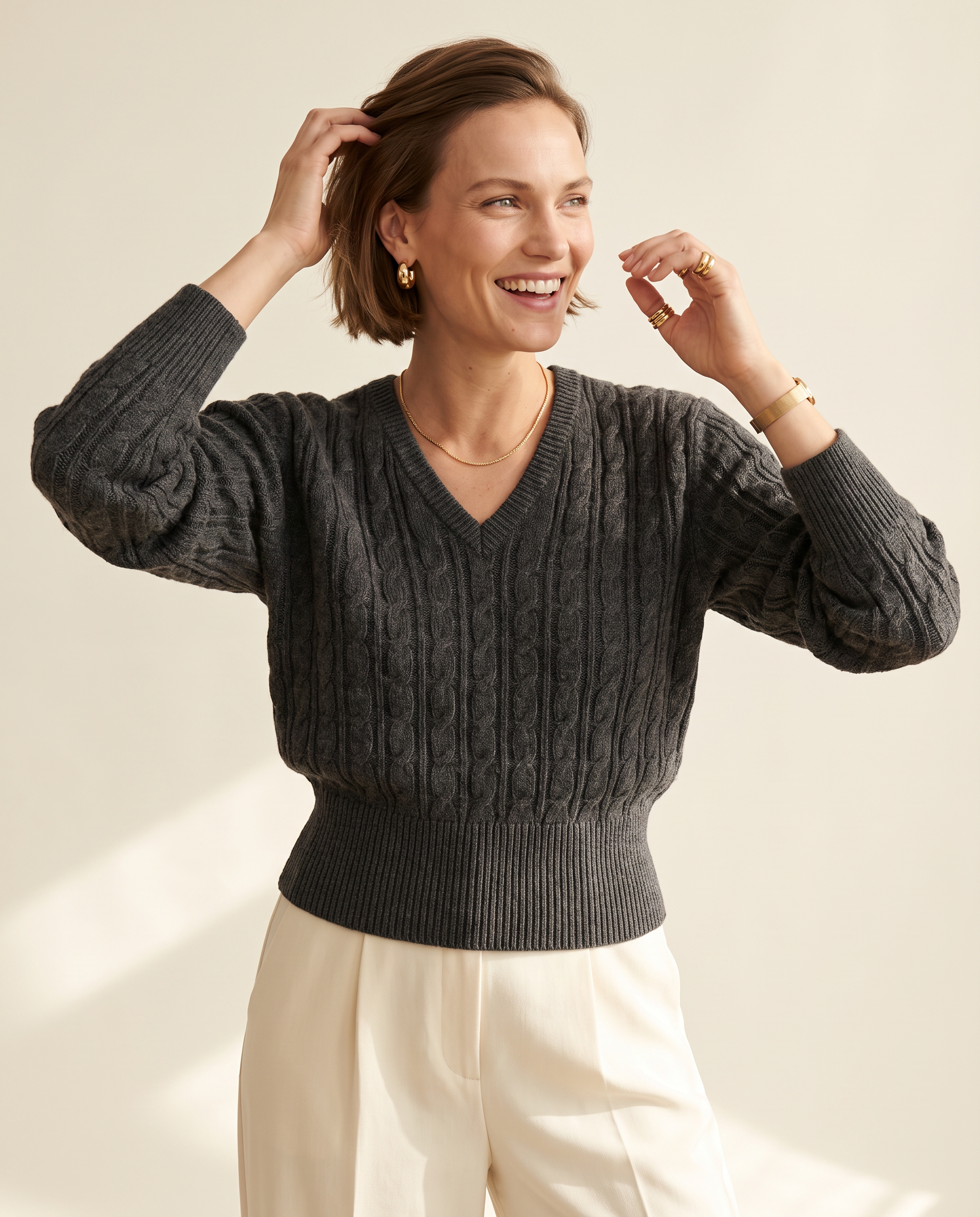 Cable V-Neck — three-quarter view, on a warm ivory studio backdrop