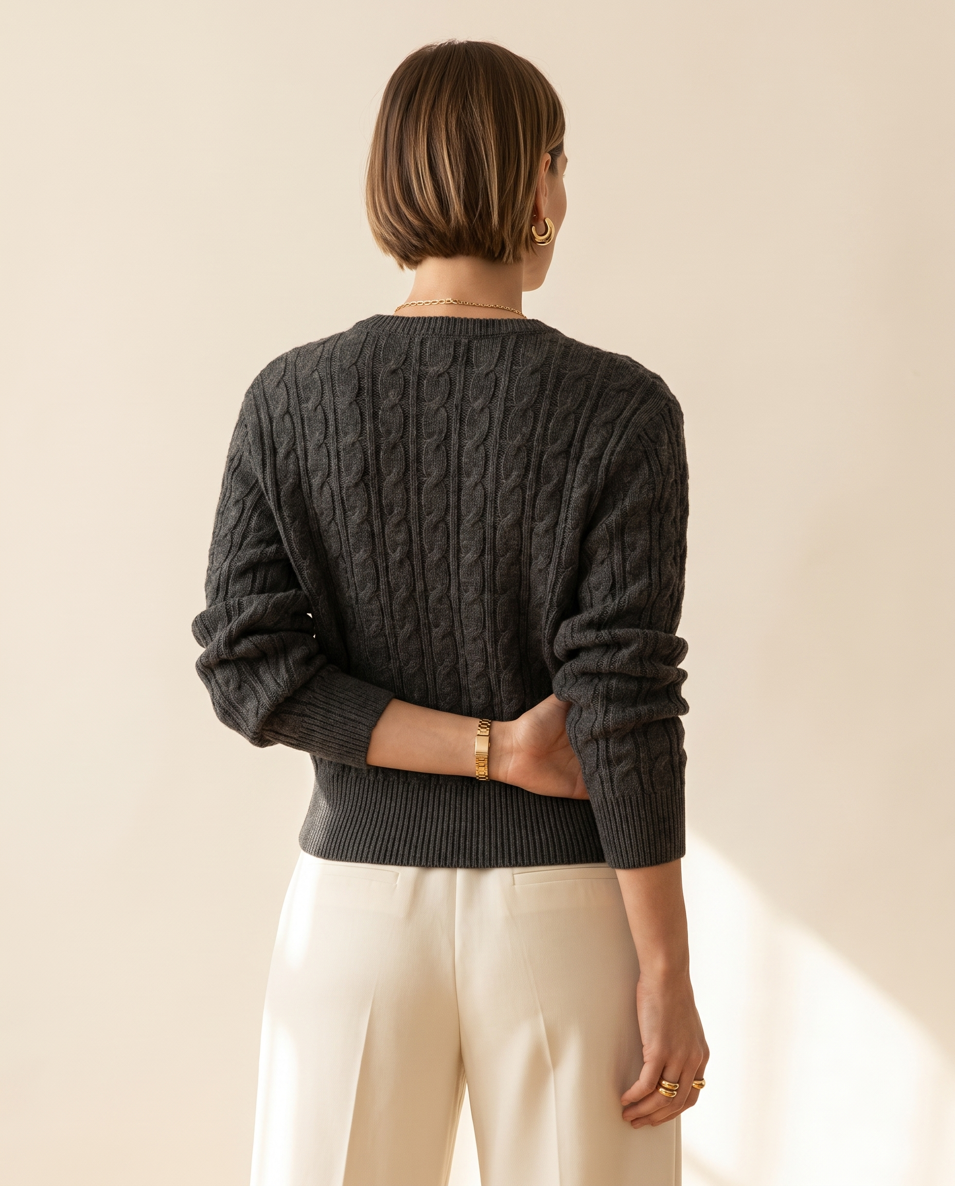 Cable V-Neck — back view, on a warm ivory studio backdrop