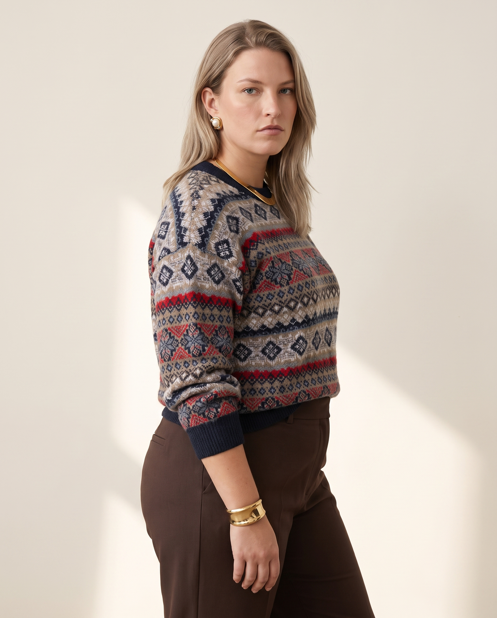 Folk Fair Isle Sweater — three-quarter view, on a warm off-white studio backdrop