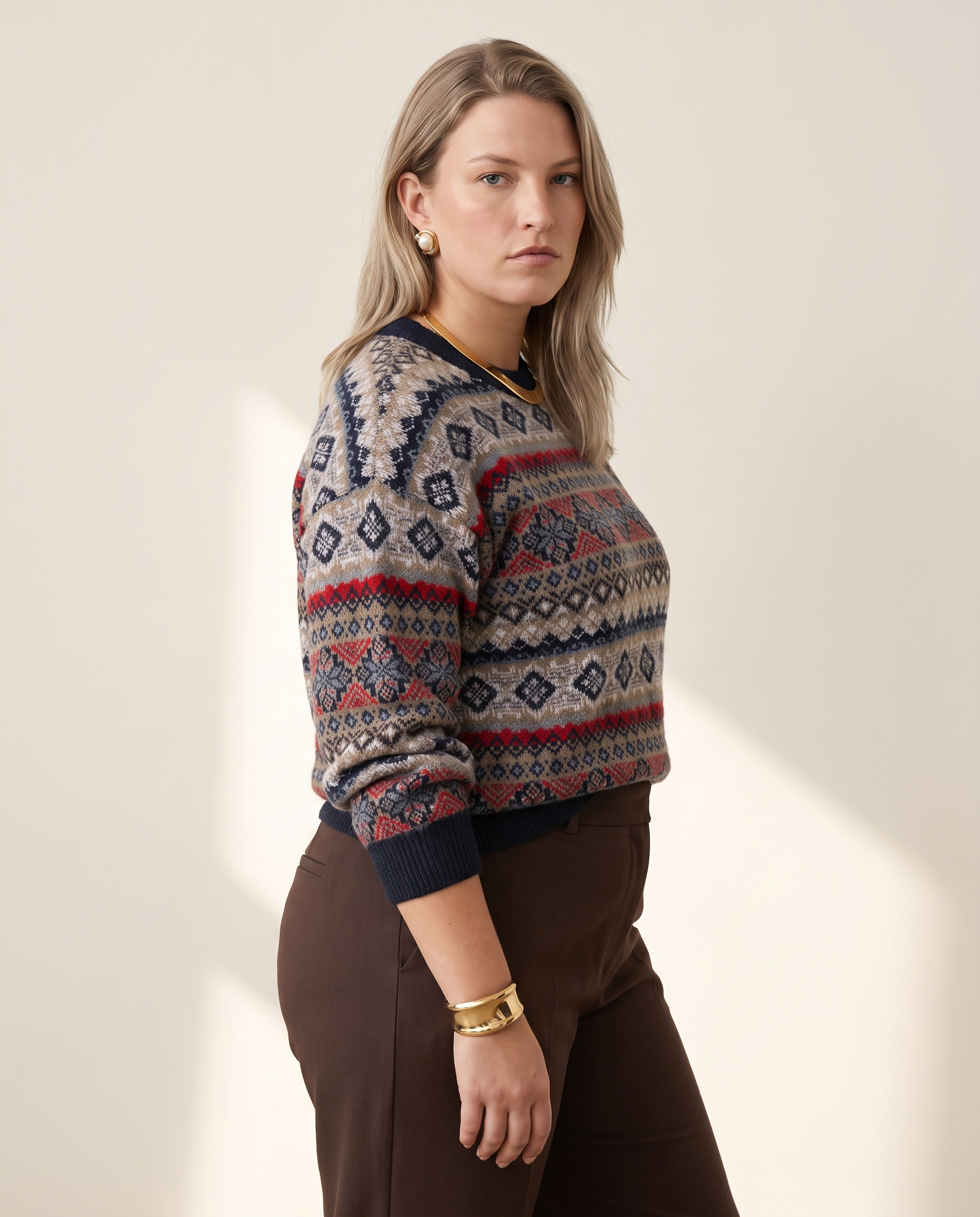 Folk Fair Isle Sweater — three-quarter view, on a warm off-white studio backdrop
