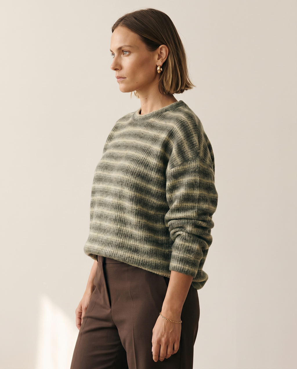 Soft Stripe Crewneck — three-quarter view, on a warm off-white studio backdrop