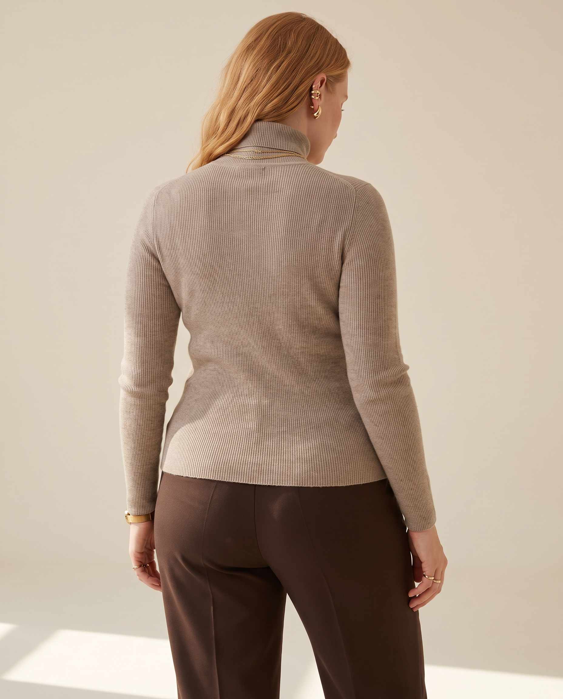 Fine Rib Roll Neck — back view, on a pale sand studio backdrop