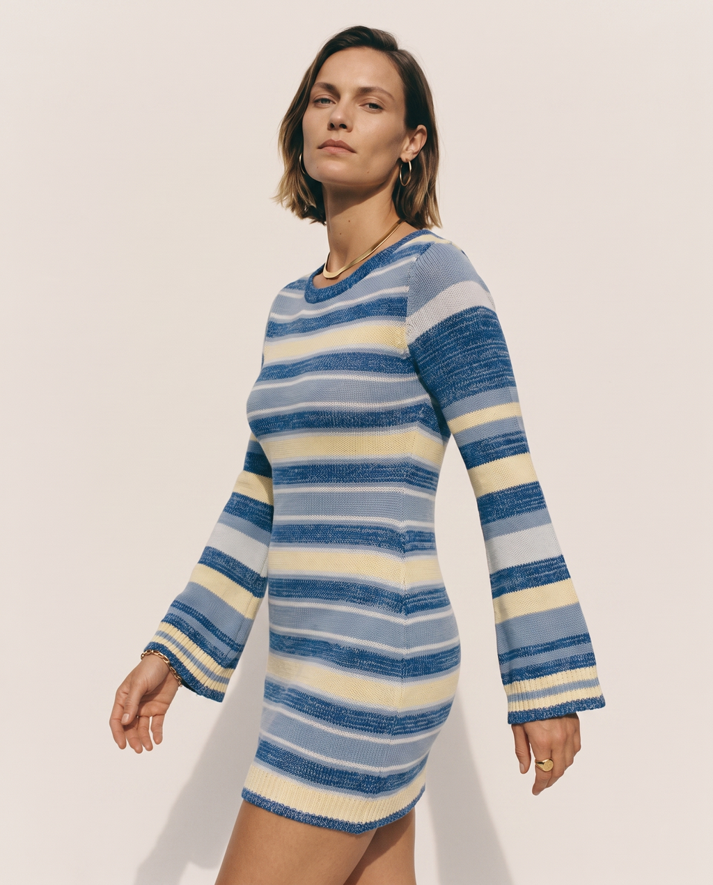 Bell Sleeve Knit Dress — three-quarter view, on a soft off-white studio backdrop
