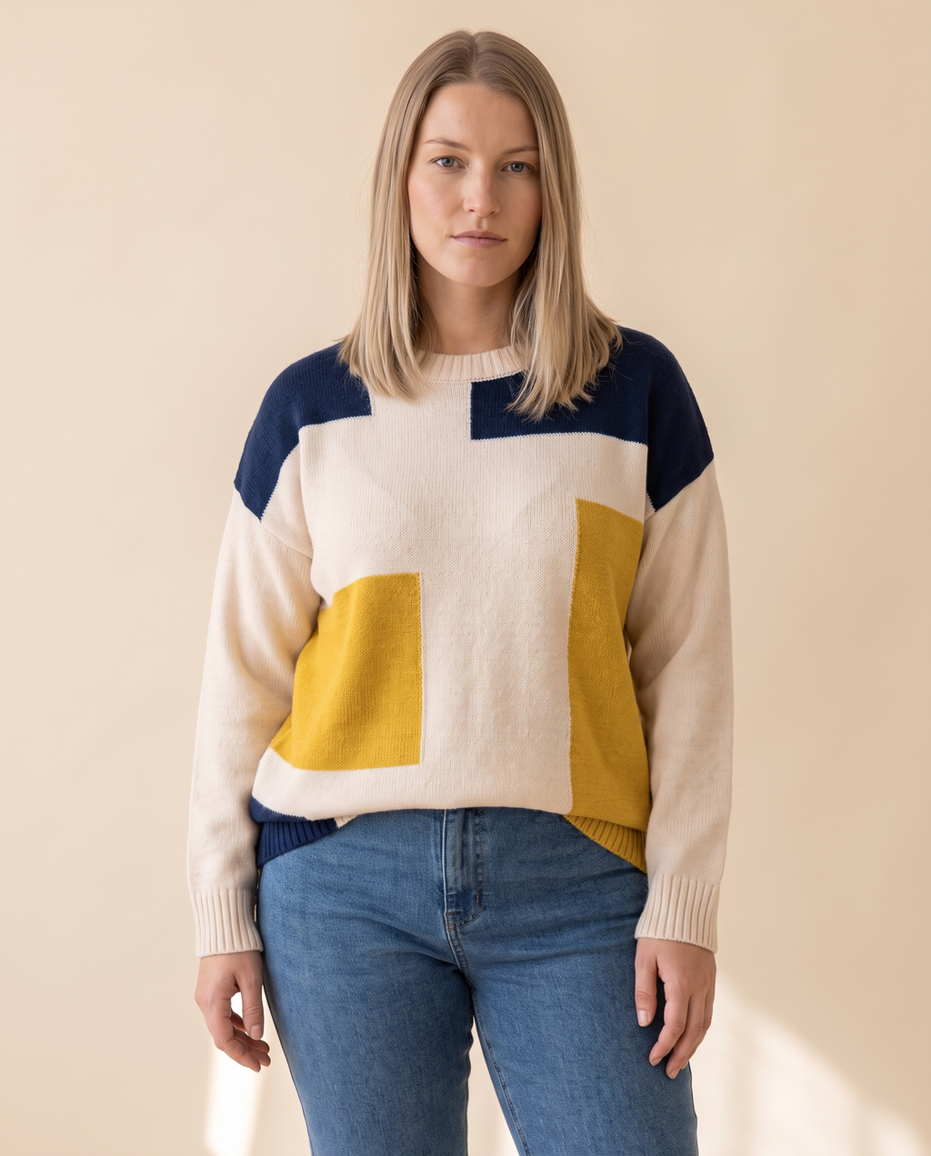 Colourblock Patch Sweater on a pale sand studio backdrop