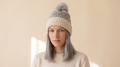 Fair Isle Bobble Hat on a pale sand studio backdrop