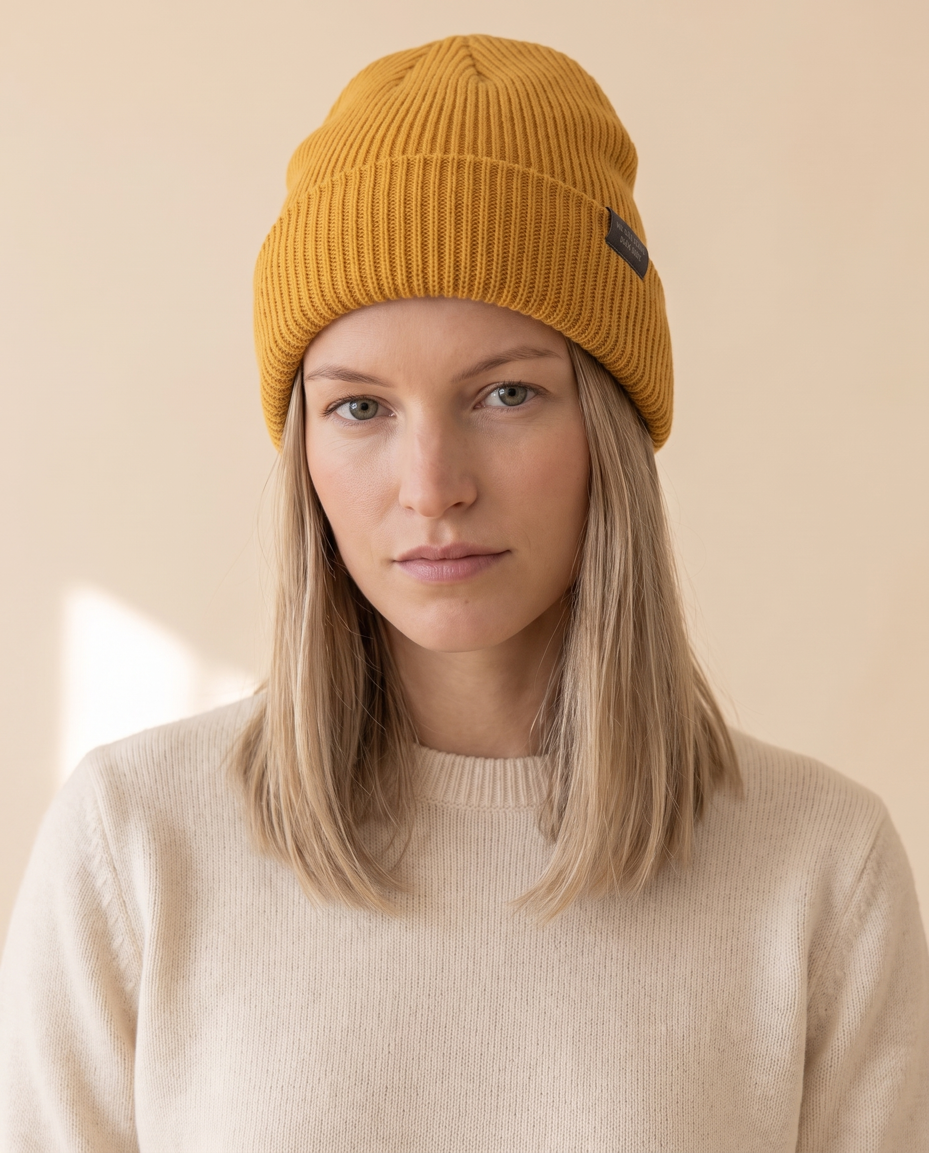 Slogan Label Beanie on a pale sand studio backdrop